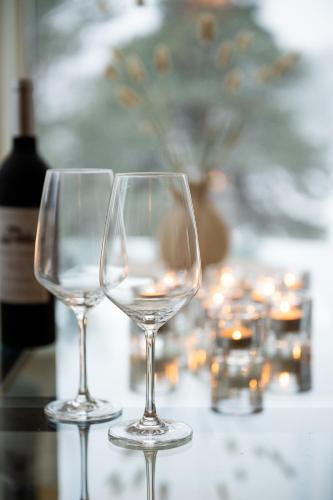 two wine glasses sitting on a table with a bottle of wine at Villa Bessberget in Edsbyn
