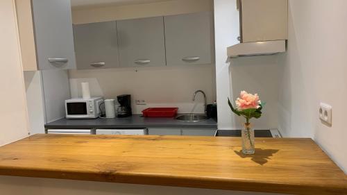 une cuisine avec une table en bois et un vase de fleurs dans l'établissement Le Calme, à Sèvres