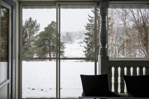 a view of a snow covered field through a window at Villa Bessberget in Edsbyn