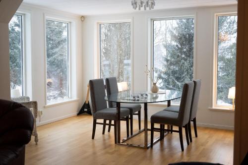 a dining room with a glass table and chairs at Villa Bessberget in Edsbyn