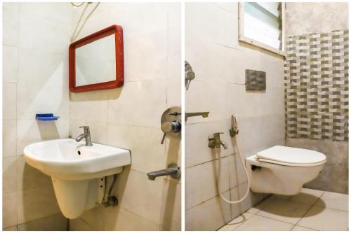 a bathroom with a sink and a toilet and a mirror at Collection O Sri Subhamastu Grand in Vijayawada