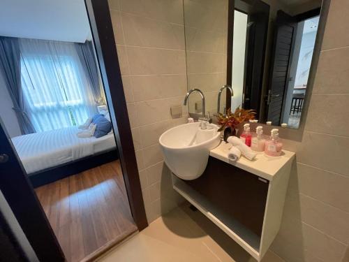 a bathroom with a sink and a mirror and a bed at Emerald Terrace Condo 10-Family One Bed & Sofa Bed Garden View in Patong Beach