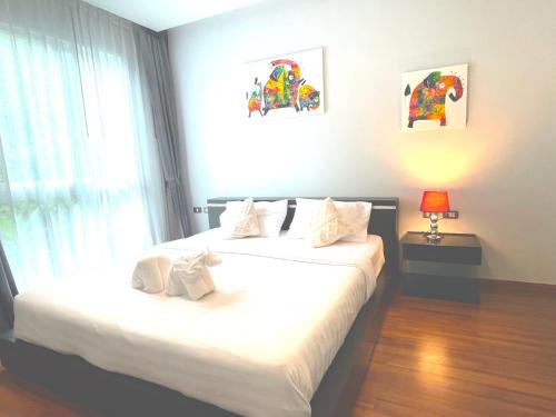 a bedroom with two beds and a window at Emerald Terrace Condo 10-Family One Bed & Sofa Bed Garden View in Patong Beach