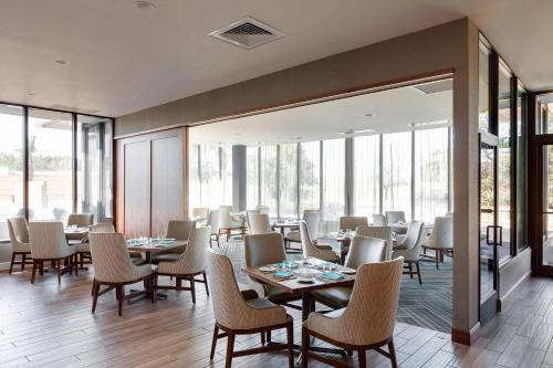 a dining room with tables and chairs and windows at North Charleston Marriott in Charleston