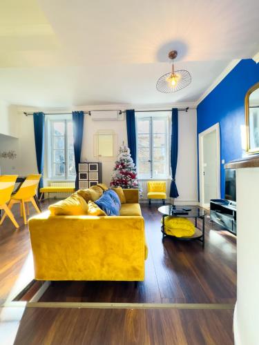 un salon avec un canapé jaune et un arbre de Noël dans l'établissement Chic Bastide, à Carcassonne