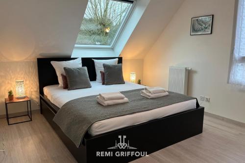 une chambre avec un grand lit avec des serviettes dessus dans l'établissement Les 4 éléments apartment 4 with balcony elevator and private parking, à Honfleur