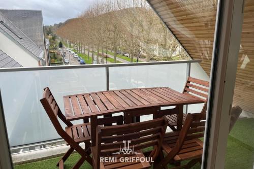 une table en bois et deux chaises sur un balcon dans l'établissement Les 4 éléments apartment 4 with balcony elevator and private parking, à Honfleur