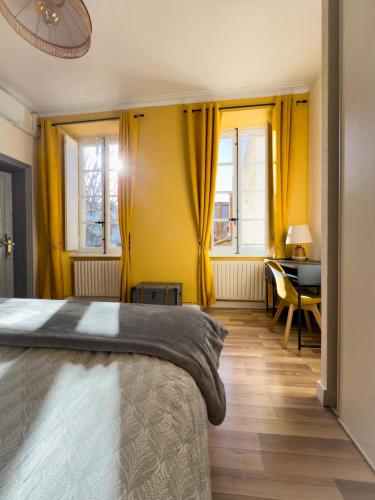 - une chambre avec des rideaux jaunes et un lit avec un bureau dans l'établissement Chic Bastide, à Carcassonne