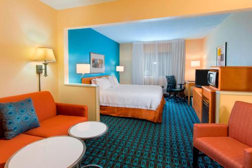 a hotel room with a bed and two chairs at Rodeway Inn in Pensacola
