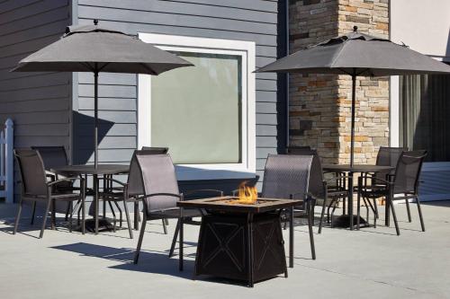 a group of tables and chairs with umbrellas on a patio at Fairfield Inn & Suites by Marriott Virginia Beach/Norfolk Airport in Virginia Beach