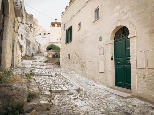 an alley with a green door in an old building at Dimora Lombardi in Matera