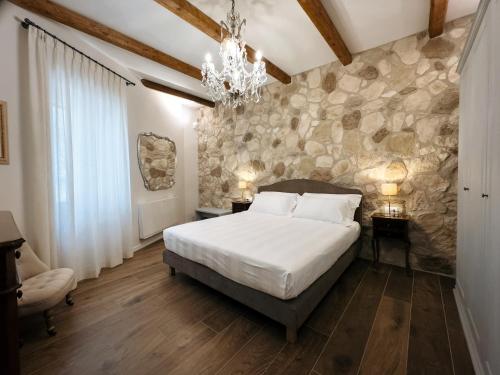a bedroom with a large bed and a stone wall at Dimora Lombardi in Matera