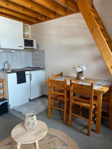 une cuisine et une salle à manger avec une table et des chaises dans l'établissement Chaleureux studio montagnard avec balcon 2402, à Prémanon