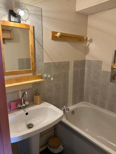 une salle de bain avec un lavabo, une baignoire et un miroir dans l'établissement Chaleureux studio montagnard avec balcon 2402, à Prémanon