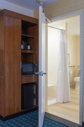 a bathroom with a door open to a bathroom with a microwave at Fairfield Inn & Suites by Marriott New York Queens/Fresh Meadows in Queens