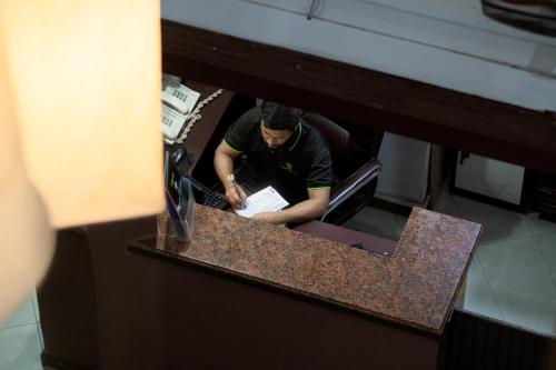 a man at a counter writing on a paper at The Park House in Male City