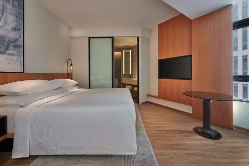 a bedroom with a bed and a table and a tv at Fairfield by Marriott Chow Kit Kuala Lumpur in Kuala Lumpur