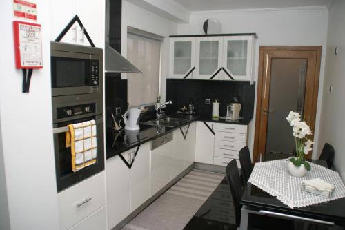 a kitchen with white cabinets and a black stove top oven at Apartamento Batista in Funchal