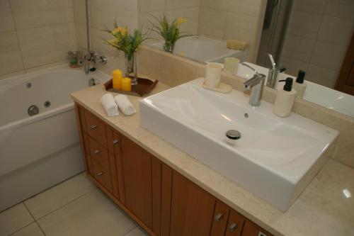 ein Badezimmer mit einem weißen Waschbecken und einer Badewanne in der Unterkunft Apartamento Batista in Funchal