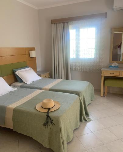 a hotel room with two beds with a hat on them at Irene Villas in Arillas