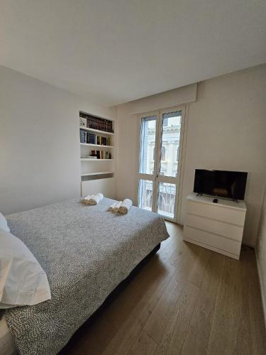 a bedroom with a bed and a tv and a window at Zen Apartment Storione in Padova