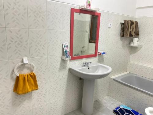 卢班戈Quartos privados em uma casa comum的带水槽和镜子的白色浴室