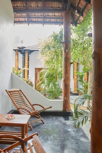 a patio with chairs and a table on a porch at Surf &Turf Arugam Bay in Arugam Bay