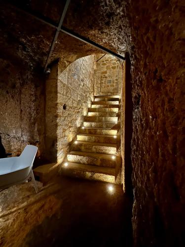 a staircase in a brick building with a white bench at Palazzo Palloni Boutique Apartment in Sorano
