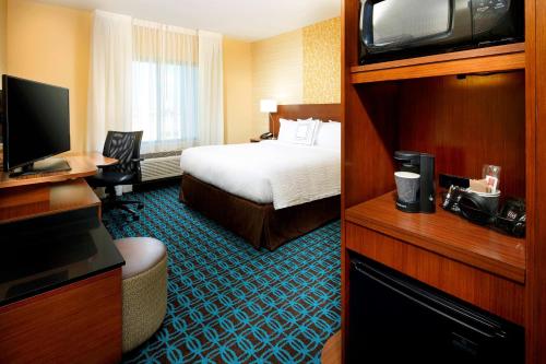 a hotel room with a bed and a television at Fairfield by Marriott Inn & Suites Wheeling at The Highlands in Triadelphia