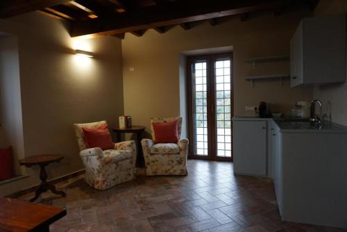 a kitchen with two chairs and a table in a room at La Locanda del Pellegrino in Bassano in Teverina