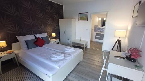 Habitación pequeña con cama blanca y escritorio. en Neferprod Apartments - IS - CAM 01, en Timisoara