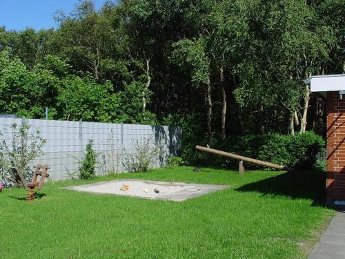 a yard with a fence and a wooden pole at Broderhus Bude in Sankt Peter-Ording