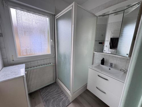 a white bathroom with a sink and a mirror at Séjour détente et confort au calme d une impasse in Garges-lès-Gonesse