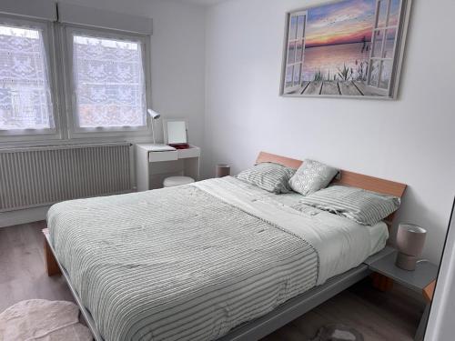 une chambre avec un lit et un tableau au mur dans l'établissement Séjour détente et confort au calme d une impasse, à Garges-lès-Gonesse