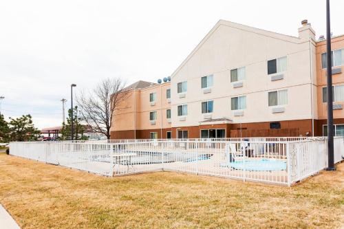 a building with a white fence in front of a building at Fairfield Inn by Marriott Ponca City in Ponca City