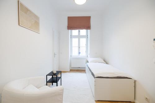 Una habitación blanca con dos camas y una ventana. en Ultra Spacious 3-Bedroom 3-Bath Steps from Vienna's Historic Heart, en Viena