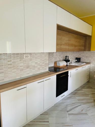 a kitchen with white cabinets and a sink at Zemun Belgrade Apartment in Belgrade