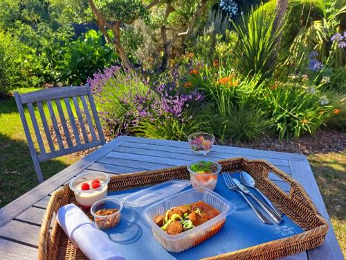a picnic table with a basket of food on it at Hôtel Traiteur Les Ormes, The Originals Relais in Barneville-Carteret