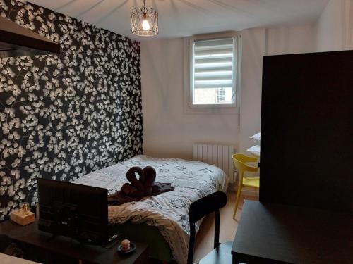 Cette chambre comprend un lit, un bureau et une télévision. dans l'établissement Beau studio - 1 personne, à Dijon