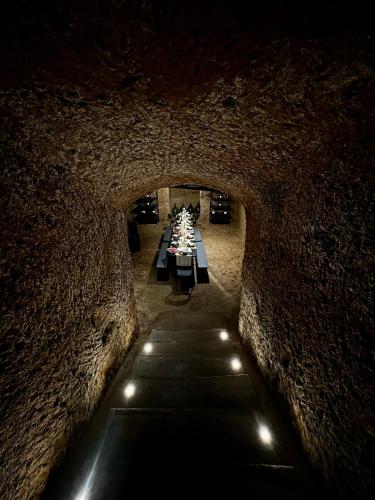 a tunnel in a stone wall with tables and lights at Palazzo Palloni: Piano Nobile in Sorano