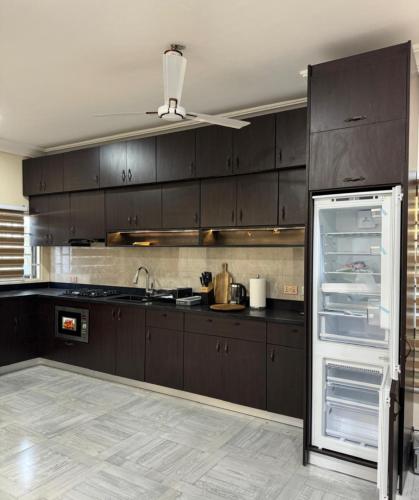 una cucina con mobili marroni e un frigorifero aperto di B4 Rentals a Accra