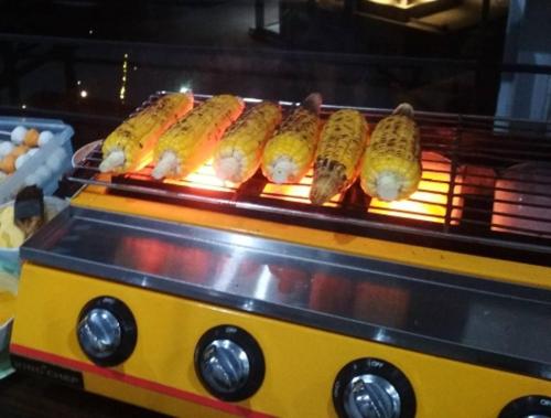 a row of sausages on a grill on a food truck at Villa Pandawa tawangmangu in Tawangmangu
