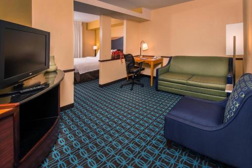 a hotel room with a television and a living room at Fairfield Inn Dulles Airport Chantilly in Chantilly