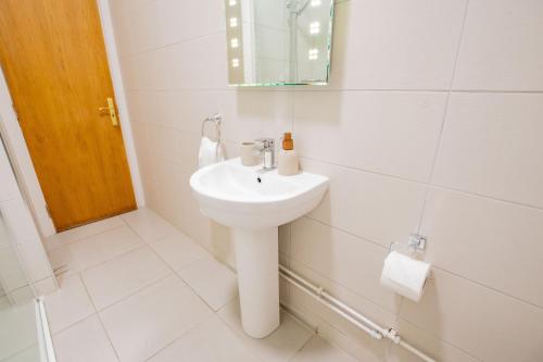 a white bathroom with a sink and a mirror at Long Walk Gem in Galway