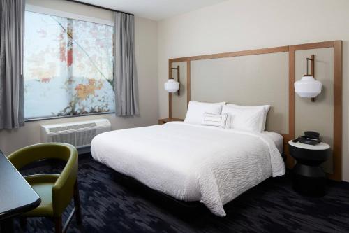 a hotel room with a bed and a desk and a window at Fairfield Inn & Suites by Marriott Riverside Moreno Valley in Moreno Valley