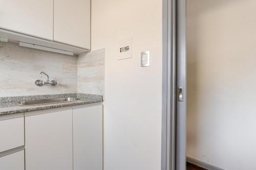 a kitchen with white cabinets and a sink at Modern apartment in front of Plaza Independencia in Mendoza