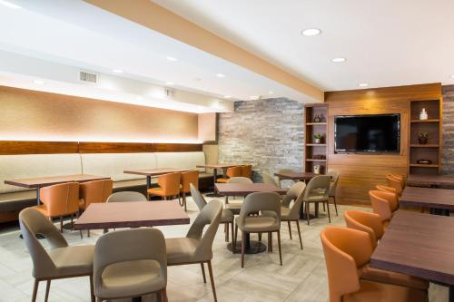 a restaurant with tables and chairs and a flat screen tv at Four Points by Sheraton Downtown Seattle Center in Seattle