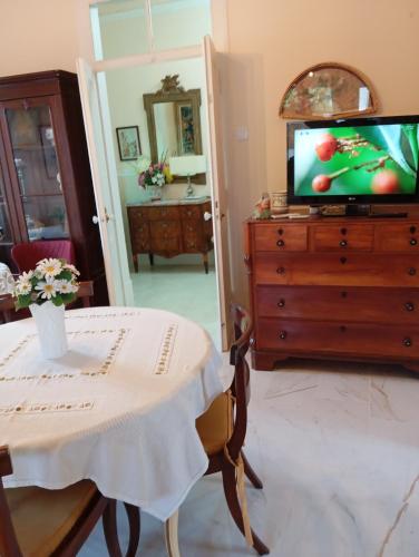 a living room with a table and a tv on a dresser at St Mary House in Tomar