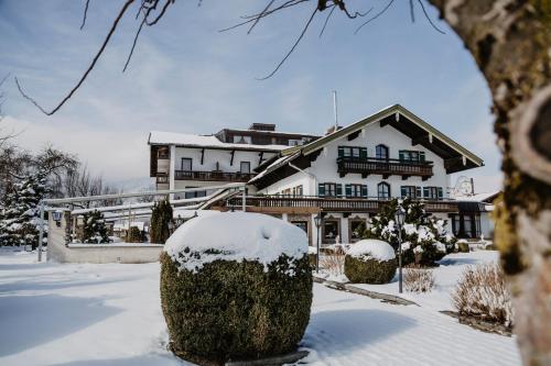 a house covered in snow in front at Weßner Hof Landhotel & Restaurant in Marquartstein