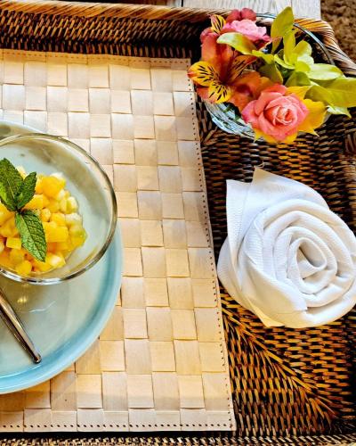 a table with a bowl of corn and a plate of flowers at Hôtel Traiteur Les Ormes, The Originals Relais in Barneville-Carteret